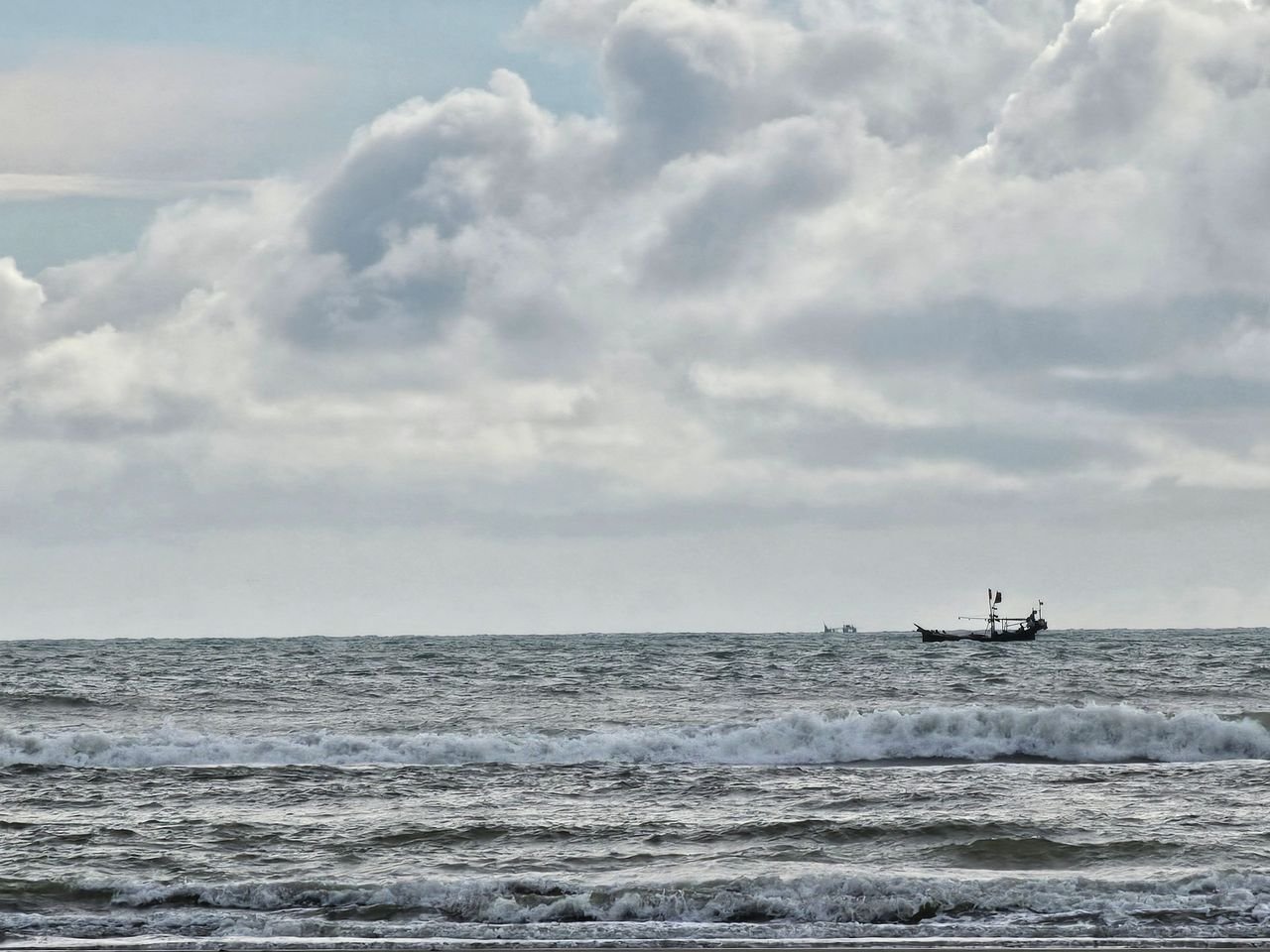 Formação Small fishing boat on a choppy sea under a cloudy sky, evoking adventure.